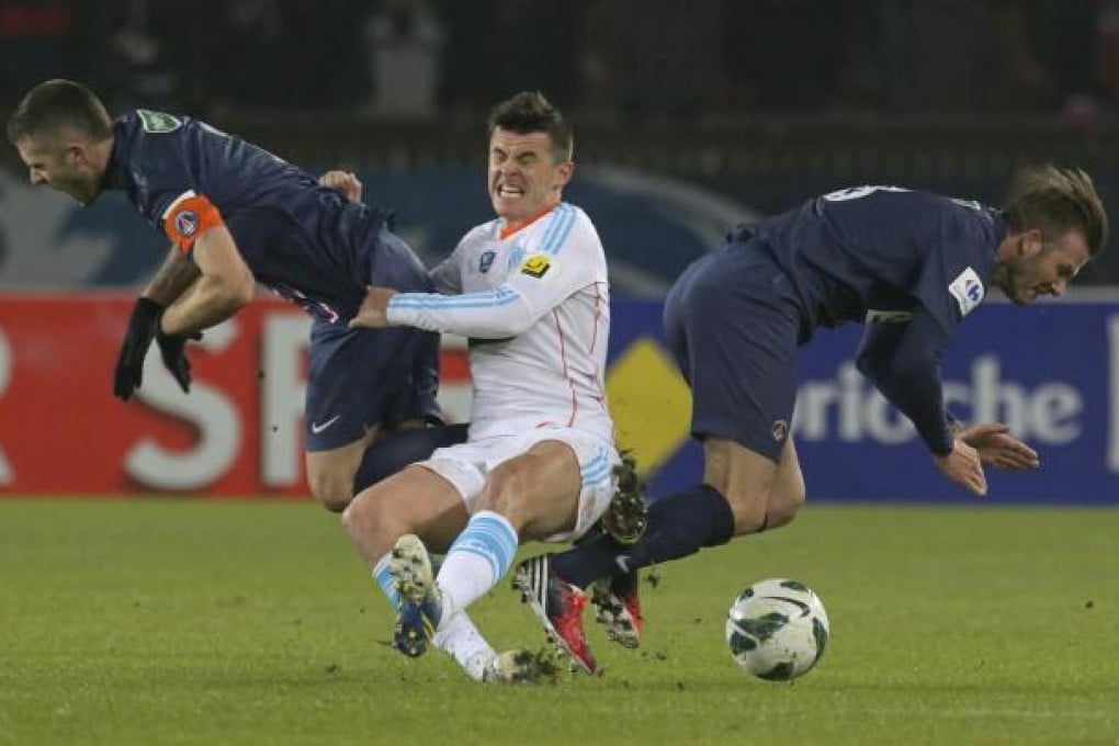 Paris Saint-Germain's David Beckham (right) and Jeremy Menez (left) lose out in a challenge for the ball with Marseille's Joey Barton at Parc des Princes stadium. Photo: AP