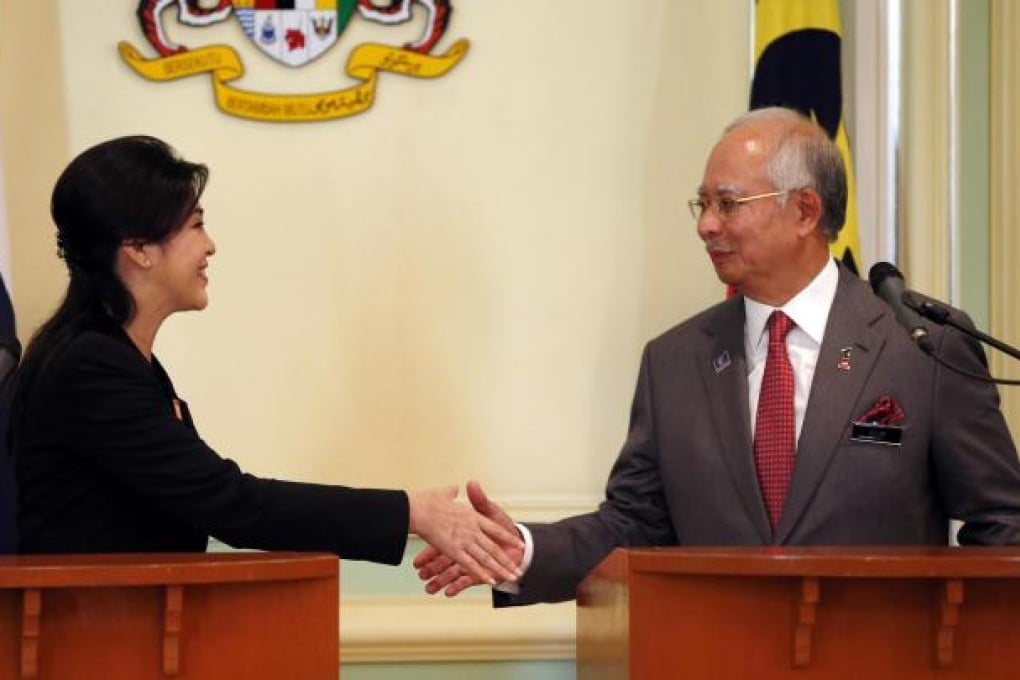 Yingluck Shinawatra and Najib Razak shake hands.Photo: AP