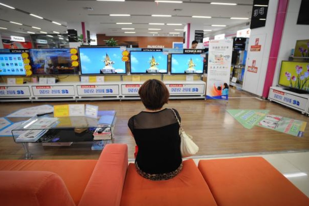 A customer looks at television sets in a branch store of retail giant Suning in Chengdu. Photo: Xinhua