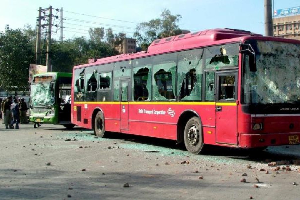 A bus with its windows shattered outside the hospital. Photo: AFP