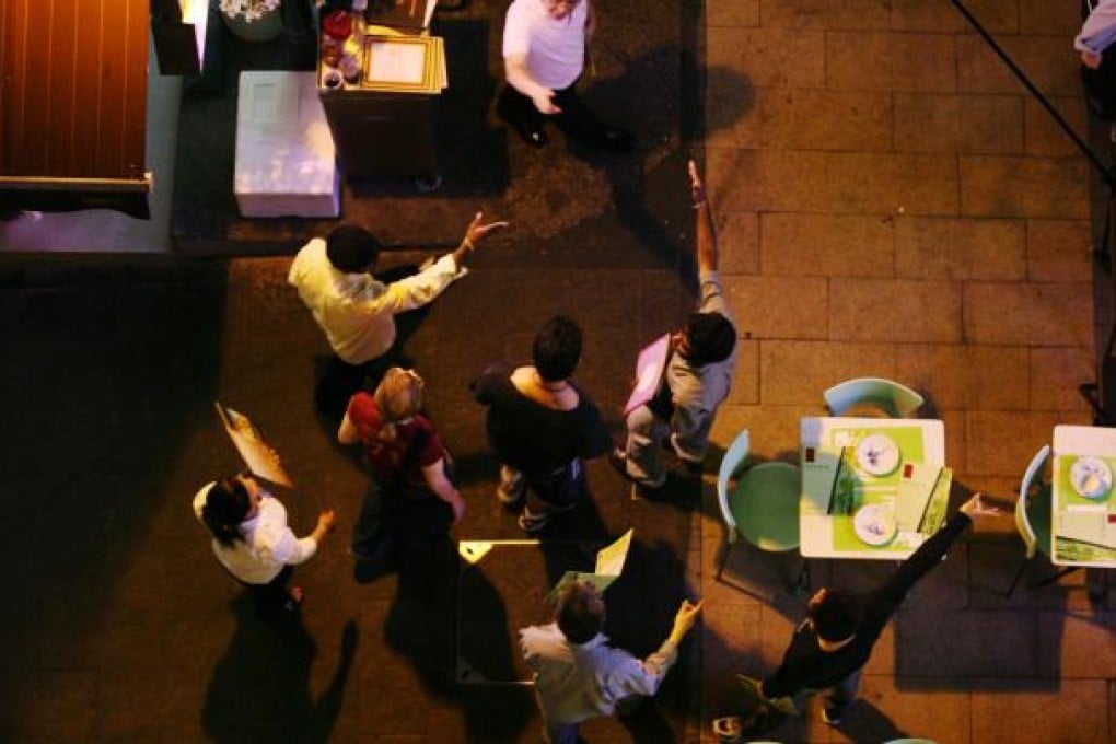 Diners welcomed by restaurant owners in Wing Wah Lane.