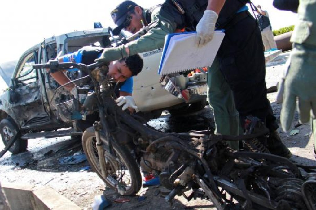 A bomb squad unit inspects the motorcycle wreckage. Photo: AFP