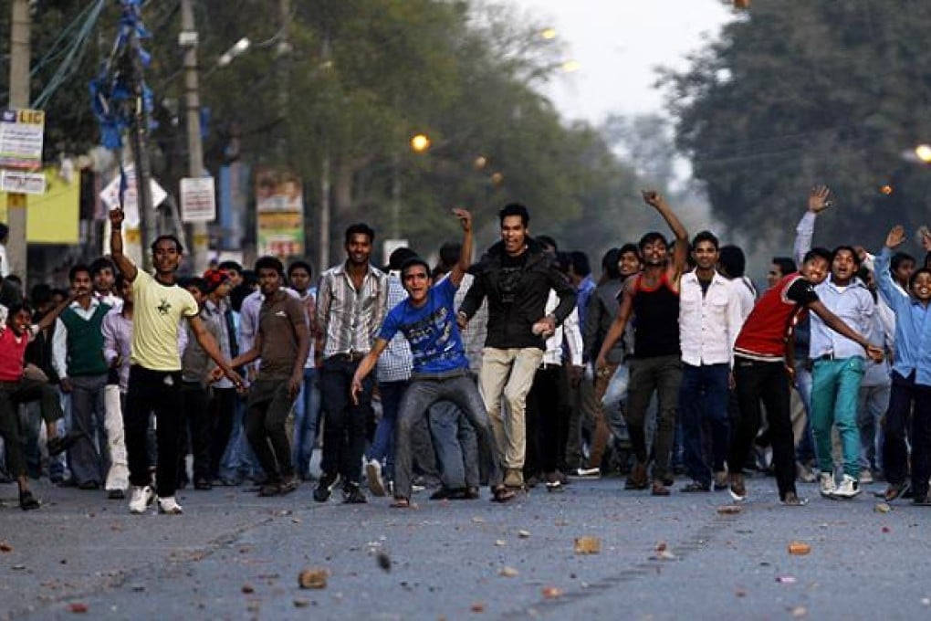 Crowds throw stones towards police officers during a protest against the rape of a 7-year-old girl in New Delhi. Photo: AP