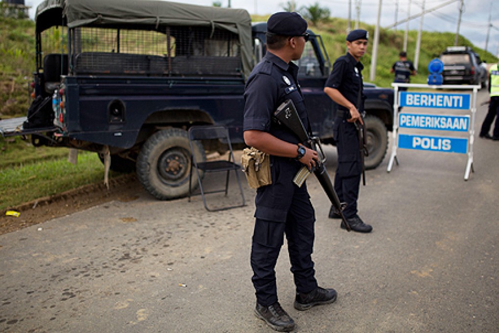 Malaysian police at a security checkpoint in Cenderawasih in Borneo on Sunday. Photo: AFP