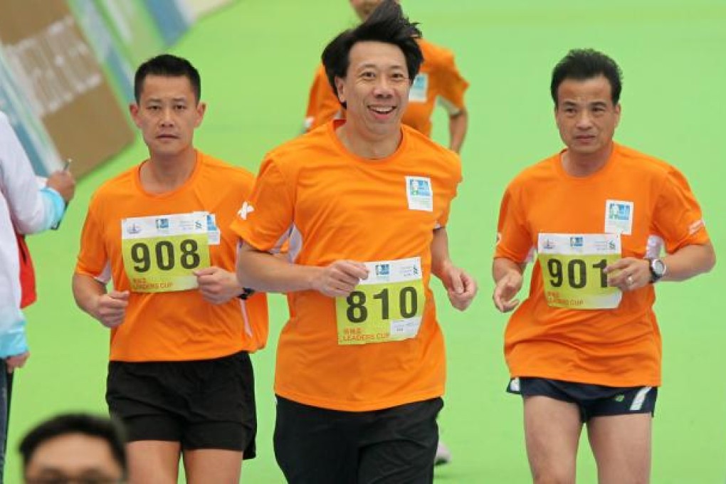 Benjamin Hung Pi-cheng, CEO of Standard and Chartered Bank (centre) crossing the finish point during the Standard Chartered Hong Kong Marathon 2013. Photo: K.Y. Cheng