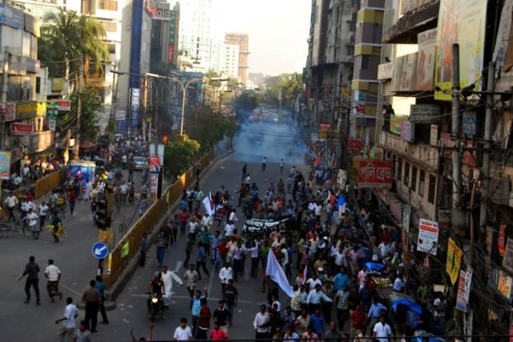 Activists run from police as teargas is fired during a protest rally in Dhaka, Bangladesh. Photo: Xinhua