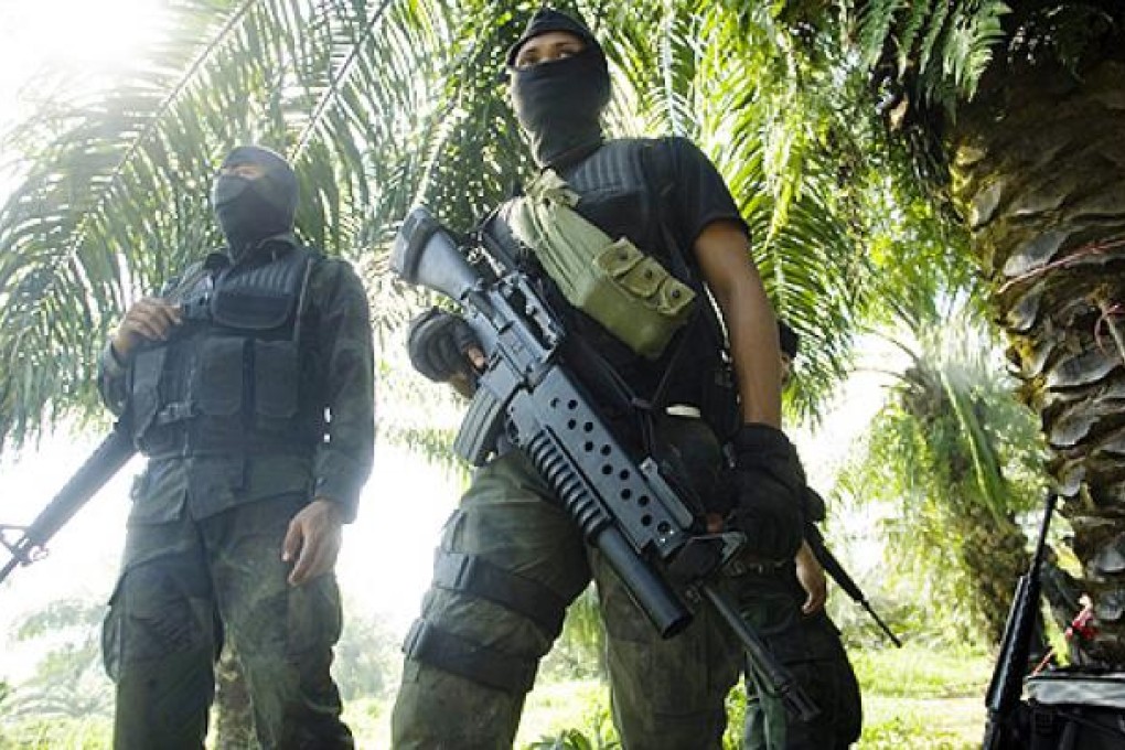 Malaysian police commandos stand guard during a stand off with armed supporters of a Filipino sultan in Malaysia's Sabah state on Borneo Island. Photo: EPA