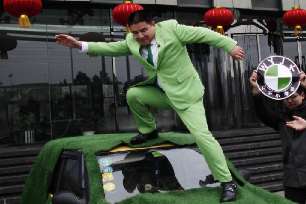Chinese multimillionaire Chen Guangbiao steps down from the roof of a car during an event organized by him in Nanjing. Photo: Reuters