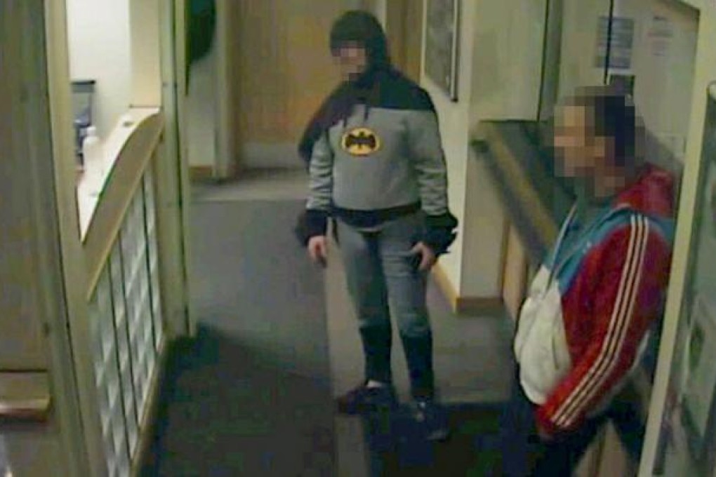 A man dressed as Batman and a burglary suspect stand in a police station in Bradford, northern England, on February 25, 2013. Photo: AFP
