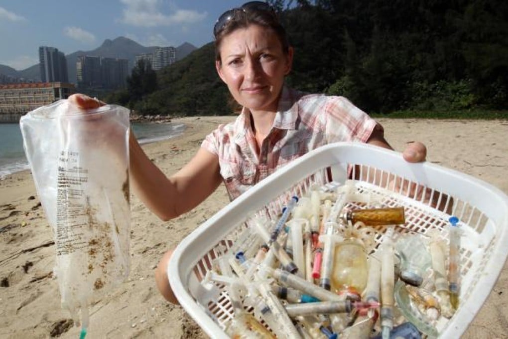 Tracey Read, of the Plastic Free Seas NGO, with some of the medical waste that has washed up on Sam Pak Wan, a beach between Discovery Bay and Disneyland, over the past four months. Read has urged the government to identify the source of the pollution. Photo: Dickson Lee
