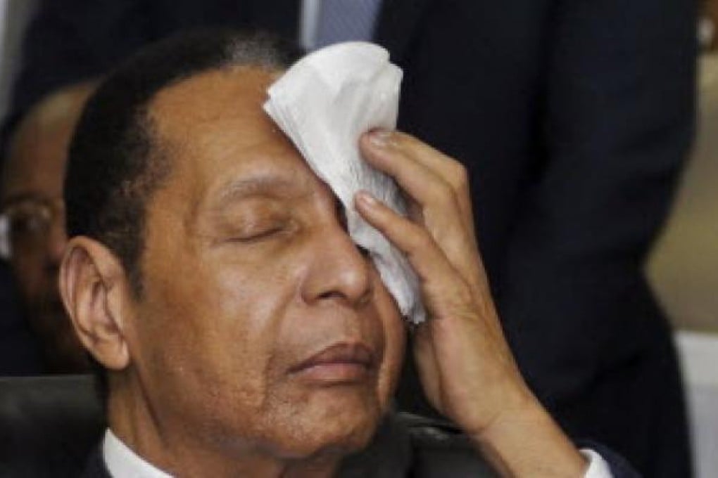 Former Haitian dictator Duvalier wipes sweat from his brow during an appeals court hearing in Port-au-Prince. Photo: Reuters