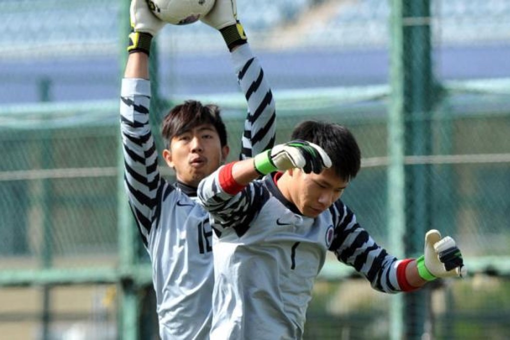 Hong Kong squad goalkeepers Tse Tak-him and Yapp Hung-fai contest a cross during the representative team’s training session at Hong Kong Football Club yesterday. Photo: Xinhua