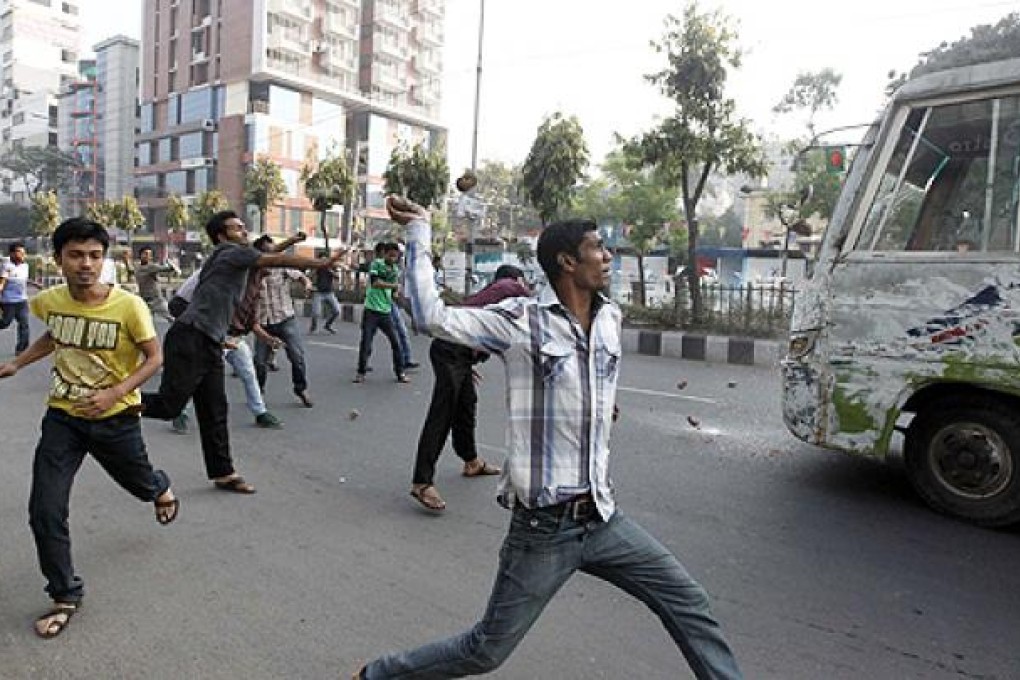 Bangladesh Nationalist Party activists throw pieces of brick as they vandalise a bus during a country wide strike in Dhaka on Thursday. Photo: Reuters