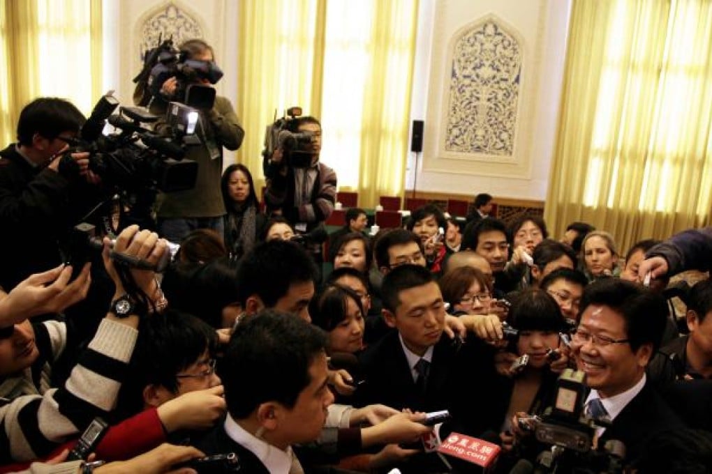 Zhang Chunxian, Communist Party chief of northwest China's Xinjiang Uygur Autonomous Region, at right, is mobbed by journalists after a briefing for the National People's Congress. Photo: AP