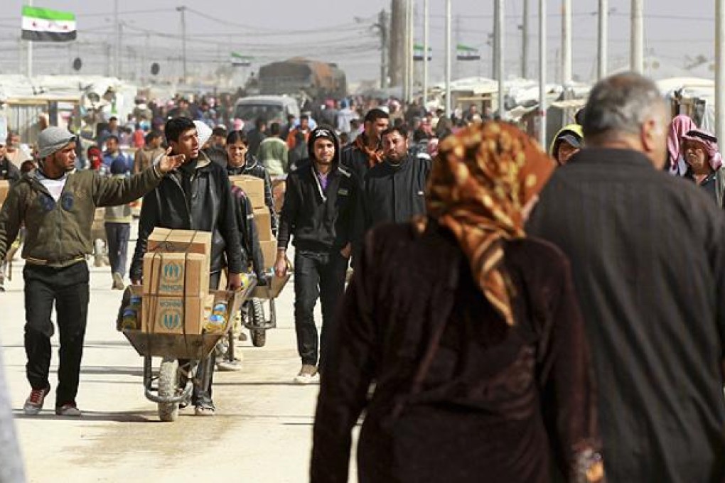 Syrian refugees collect aid and rations at Al Zaatri refugee camp in Mafraq. Photo: Reuters