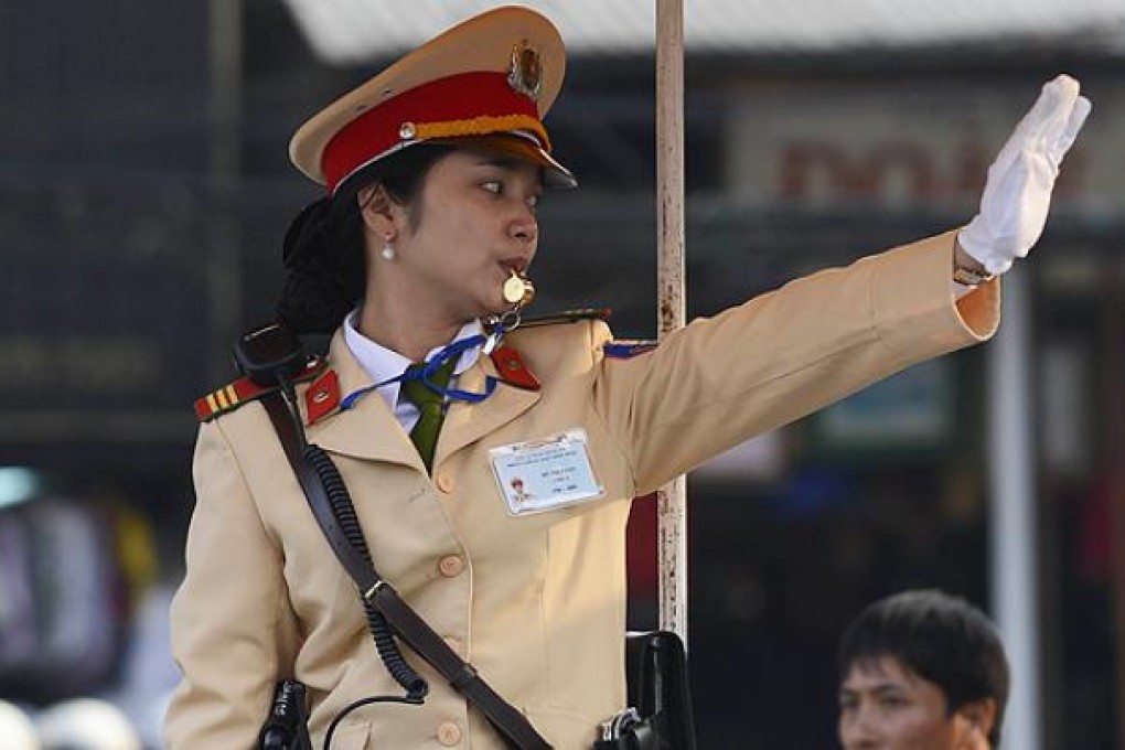 A traffic policewoman directs traffic in Hanoi. Photo: AFP