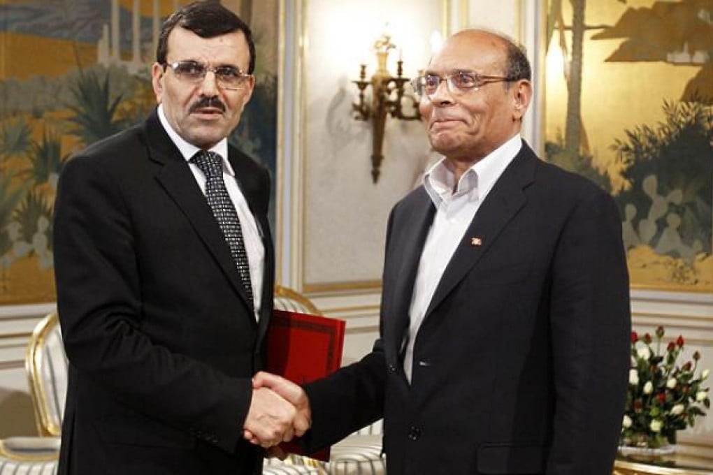 Tunisian President Moncef Marzouki shakes hands with Prime Minister Ali Larayedh in Tunis. Photo: Reuters