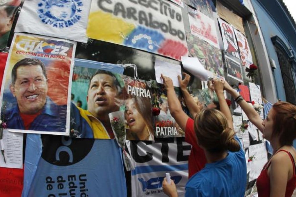 People place messages of condolences on a wall during a rally honouring late Venezuelan President Hugo Chavez. Photo: Reuters