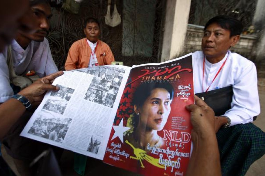 Delegates read a local news journal containing news about the NLD's congress before attending the day's session of the congress in Yangon. Photo: Reuters