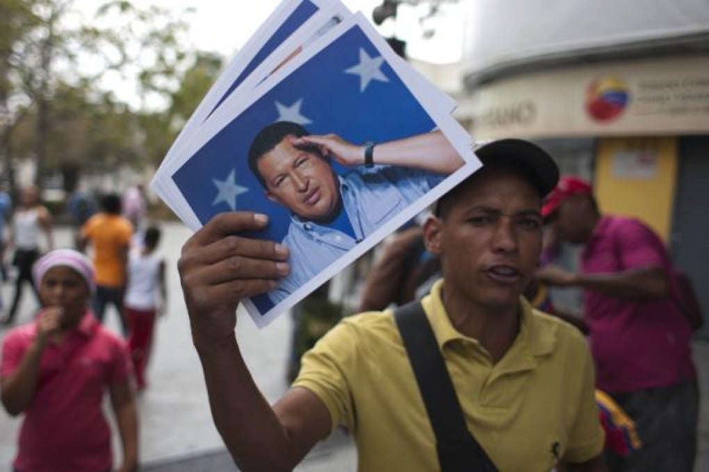 A man sells photos of the late Venezuelan President Hugo Chavez at the Simon Bolivar Square, in Caracas, Venezuela. Photo: Xinhua