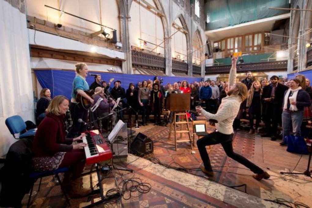 Comedians Sanderson Jones (right) and Pippa Evans (second from left) lead "worshippers" in song during an atheist service. Photo: AFP