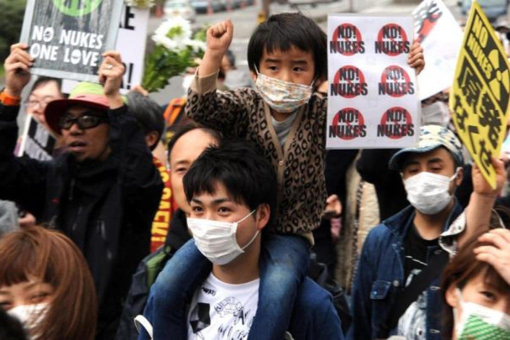 A father and son take part in a demonstration against nuclear power that was held near the Diet in Tokyo yesterday, on the eve of the second anniversary of Japan's tsunami and nuclear disaster. Photo: AFP