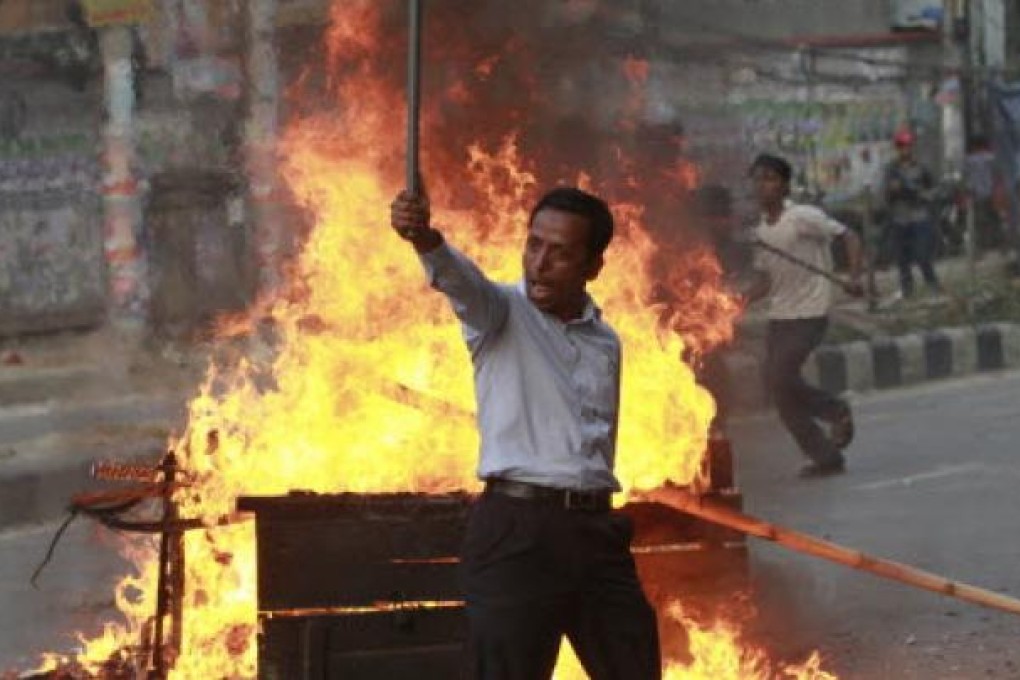 An activist of Jamaat-e-Islami gestures to the police during a clash in Dhaka. Police in Bangladesh’s capital clashed with protesters again on Tuesday. Photo: Reuters
