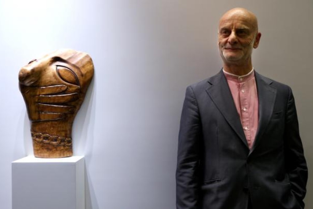 Swiss collector Dr Uli Sigg donates HK$1.3 billion worth of artworks to the West Kowloon Cultural District Authority. He poses with Wang Keping's wooden sculpture Chain. Photo: Sam Tsang