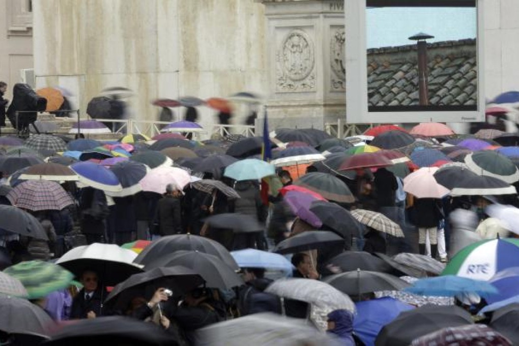 The faithful watch on a monitor the chimney on the top of the Sistine Chapel for a sign that the new pope has been chosen. Photo: AP