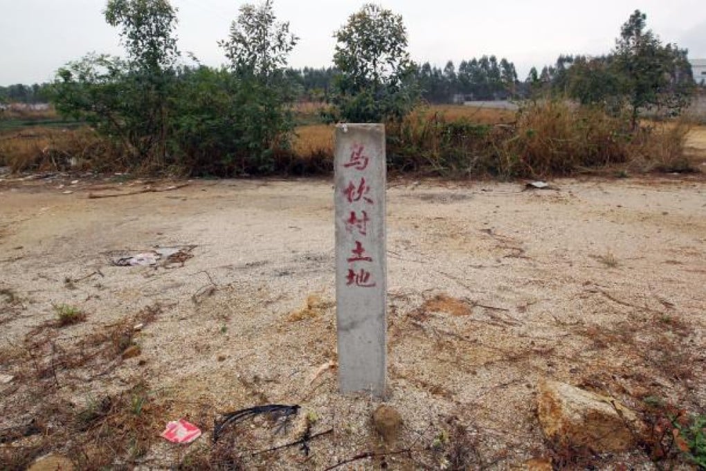 A pole with Chinese words that read "the land of Wukan".