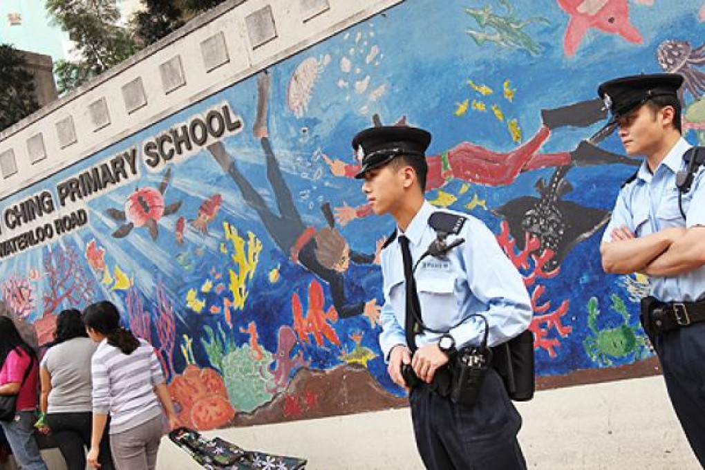 Police officers stand guard outside Pui Ching Primary School in Ho Man Tin on Monday. Photo: David Wong