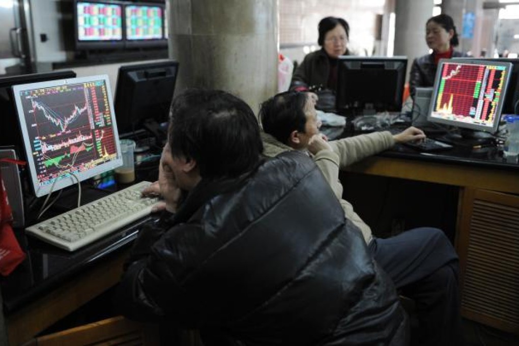 Still waiting...Investors look at a stock prices on computer screens at a securities exchange in Shanghai. Photo: AFP
