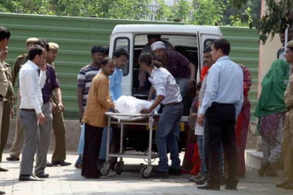 Relatives of Ram Singh, one of the six men accused of raping a student on a bus and found dead in Tihar Jail, transfer his body to an ambulance in New Delhi. Photo: Xinhua
