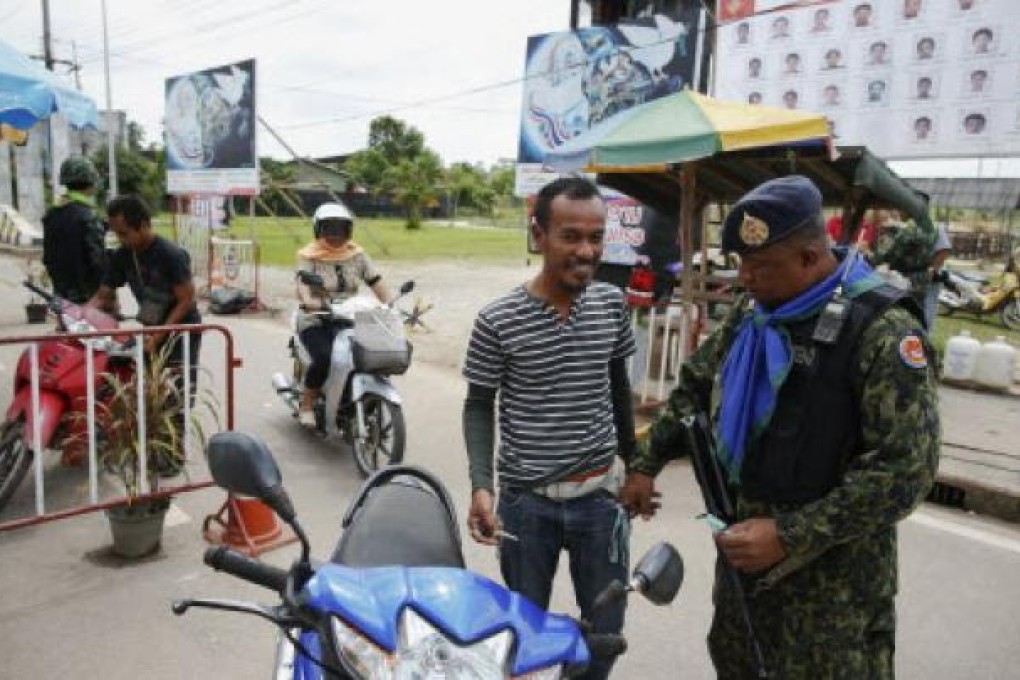 People are searched by soldiers at a checkpoint in the southern Narathiwat province. Thailand and one of several rebel groups in the country’s Muslim south will open peace negotiations in Malaysia later this month. Photo: EPA
