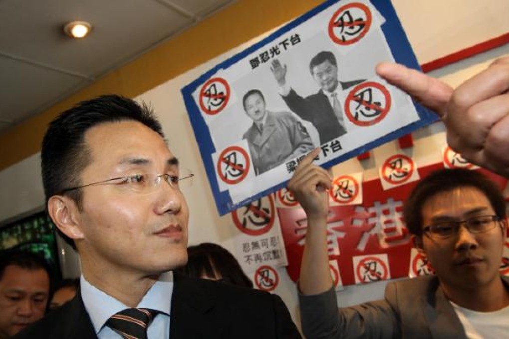 Roy Tang, the director of broadcasting, meets media at RTHK headquarters in Kowloon Tong where a protester shows a picture of him in a Hitler outfit. He is accused of editorial interference. Photo: Sam Tsang