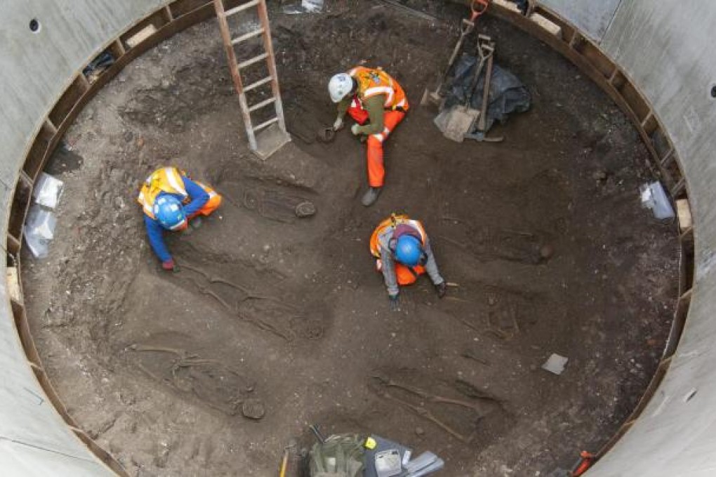 Crossrail staff excavate some of the remains. Photo: EPA