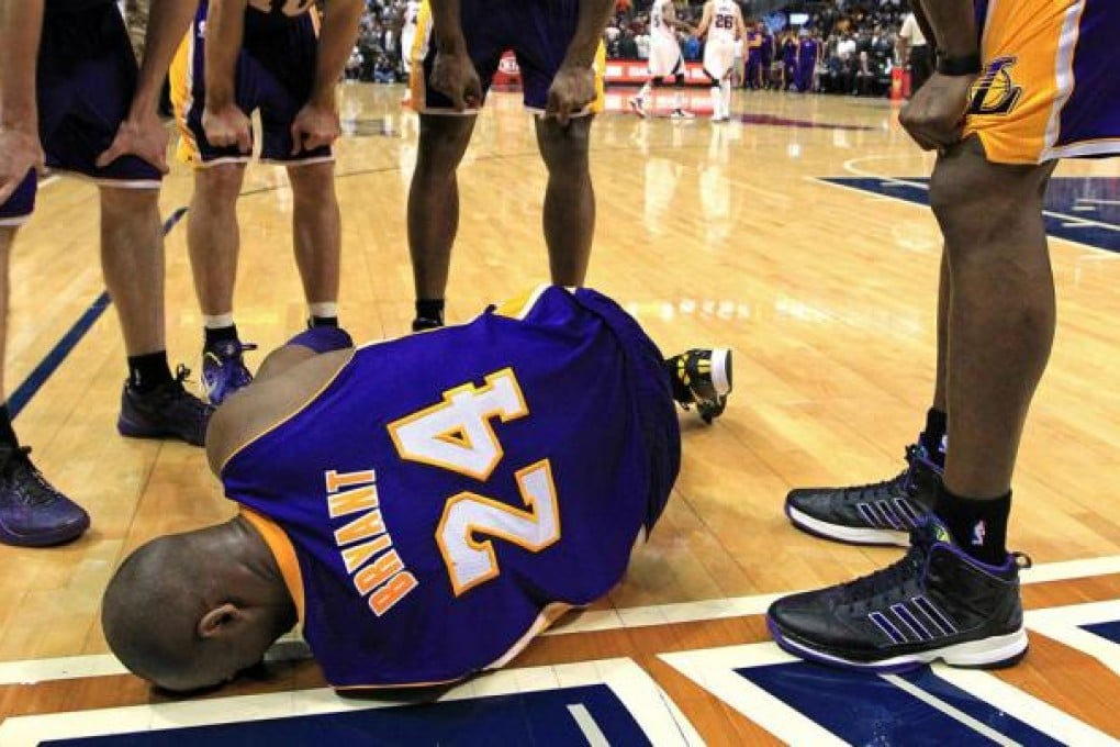 Kobe Bryant's Lakers teammates look on in consternation after he hit the deck in the final minute of the defeat to the Hawks. Photo: MCT