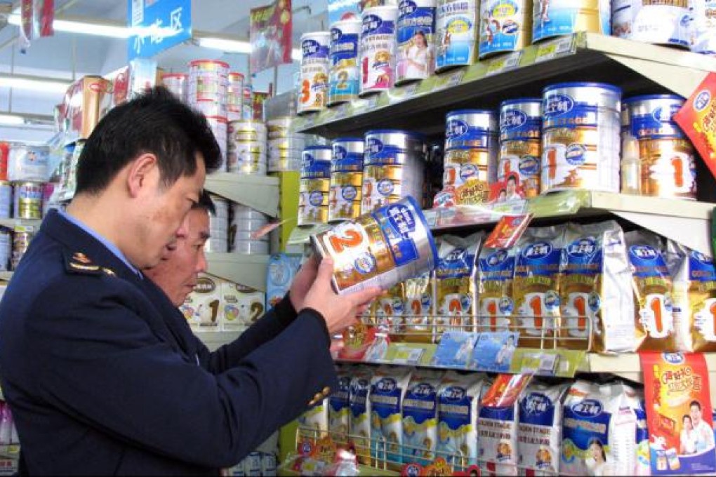 Officers inspect milk powder in a shop in Tongzi, Guizhou. Photo: AFP