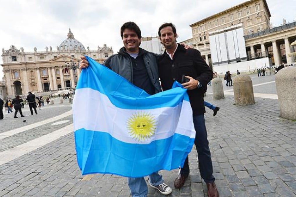 People hold an Argentinian flag in St Peter's square in Rome. The Vatican rejected claims that Pope Francis did not do enough ito save two priests kidnapped and tortured by the Argentinian military junta. Photo: AP