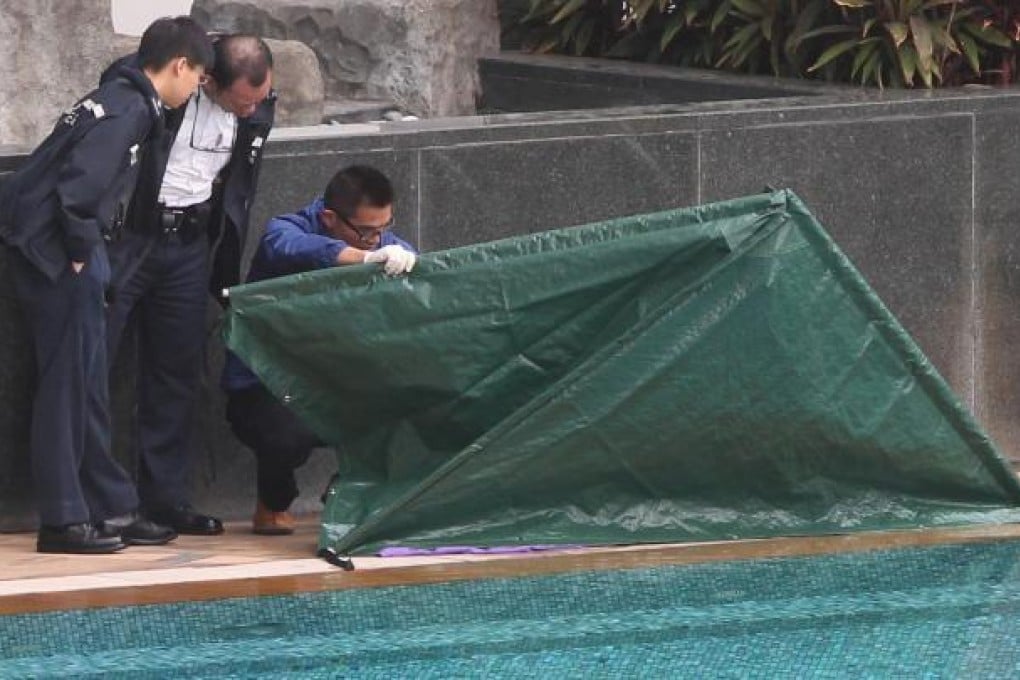 Investigators inspect the body of a woman on a Kowloon estate.
