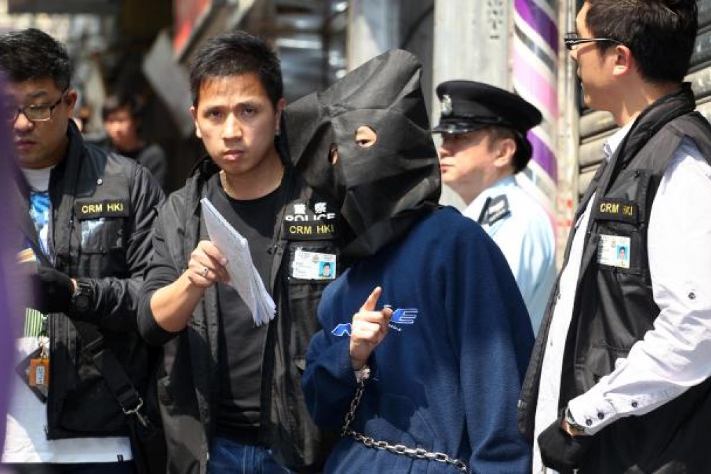 Officers take the son, 29, of the victims to a flat at Kok Cheung Street in Tai Kok Tsui. Photo: Felix Wong