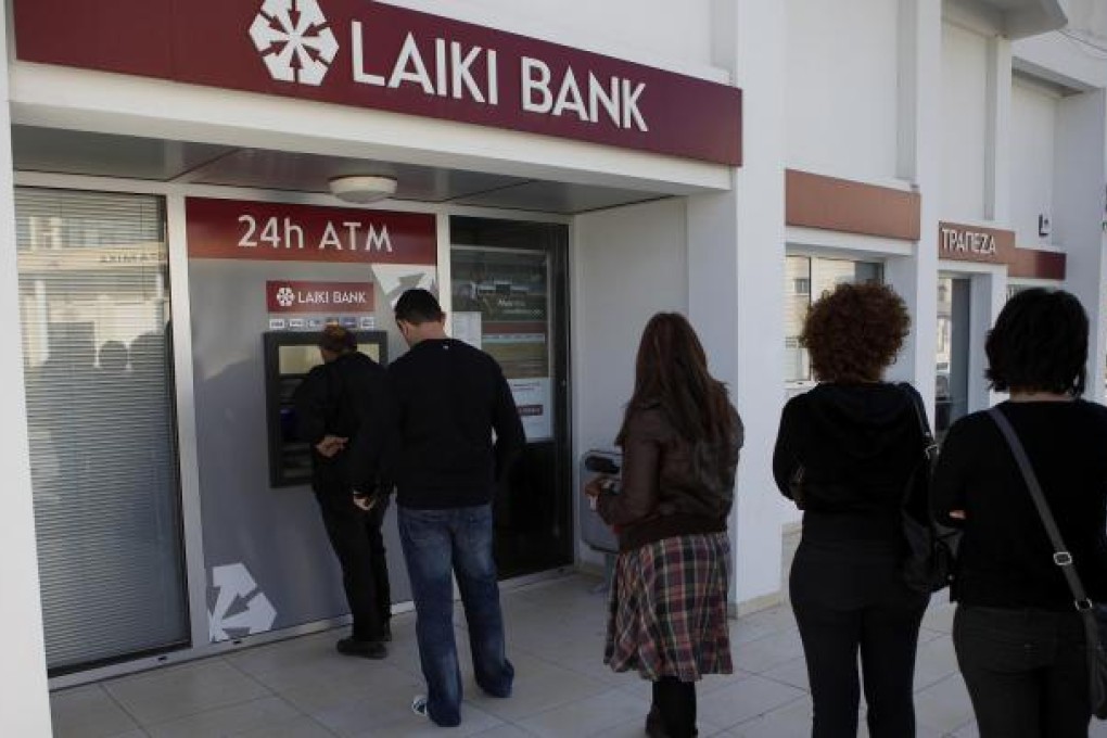 People queue at an ATM in Larnaca, Cyprus, yesterday. Photo: AP