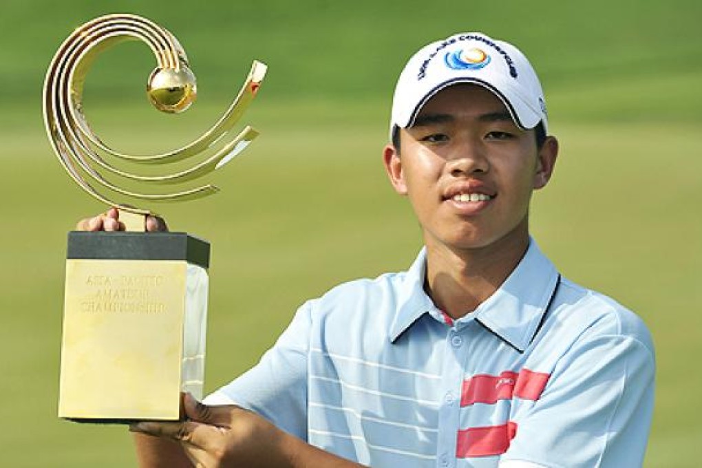 Guan Tianlang of China poses with the winner's trophy at the Asia-Pacific Amateur Championship at Amata Spring Country Club, in Thailand, in November. Photo: AP