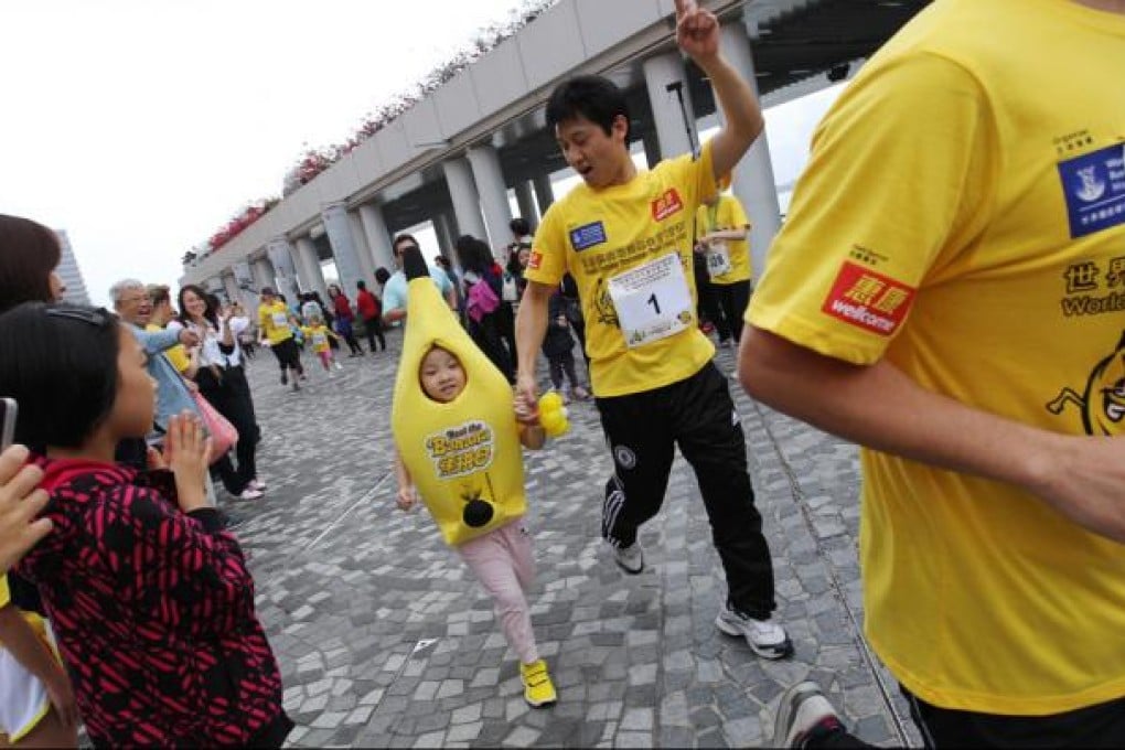 Little kids and big kids go bananas on the Tsim Sha Tsui promenade yesterday in the eighth Beat the Banana charity run. With a new 1km children's route, more than 1,600 bananas did the run - watched by people dressed as corn, strawberries and other healthy treats. The race raises money for cancer prevention awareness. Photo: Nora Tam