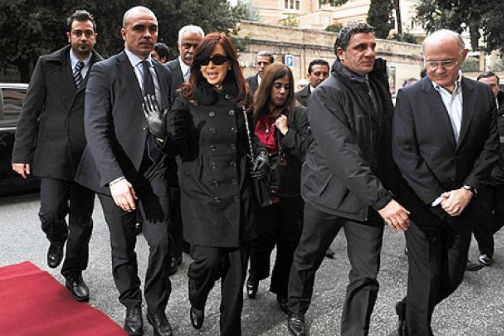 Argentine President Cristina Fernandez de Kirchner (centre) waves next to Foreign Minister Hector Timerman (right), upon arrival in Rome on Sunday. Photo: AFP