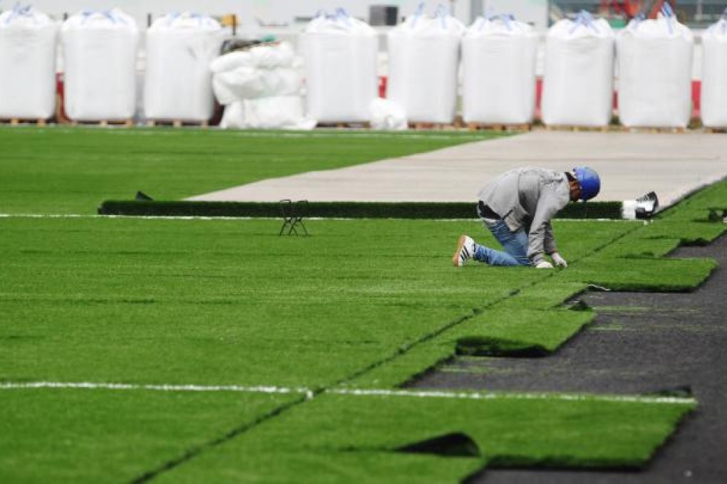 Artificial turf is placed at Happy Valley racecourse. It's cheaper and tougher, but residents say it will raise temperatures. Photo: K. Y. Cheng