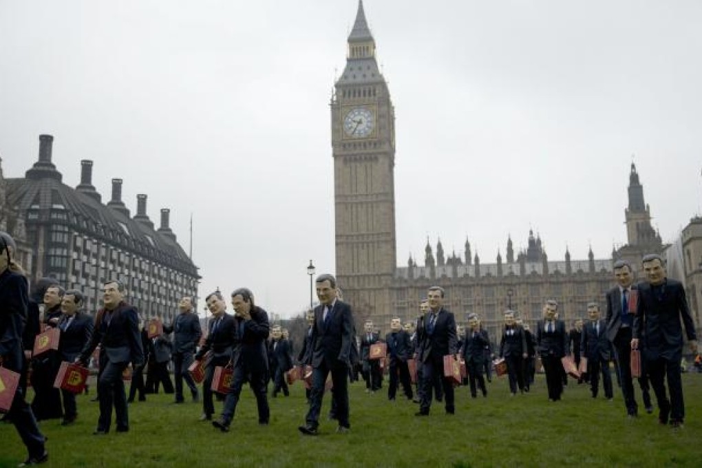 Protestors wearing wearing masks, suits and holding copies of the traditional red ministerial box to represent Britain’s Chancellor of the Exchequer George Osborne on budget day, walk across Parliament Square. Osborne is expected to stick to his guns and deliver a tough budget later on Wednesday. Photo: AP