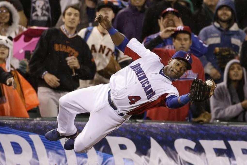 The Dominican Republic's Miguel Tejada dives to catch a foul ball hit by Puerto Rico's Jesus Feliciano in the seventh inning of their World Baseball Classic final. Photo: AP