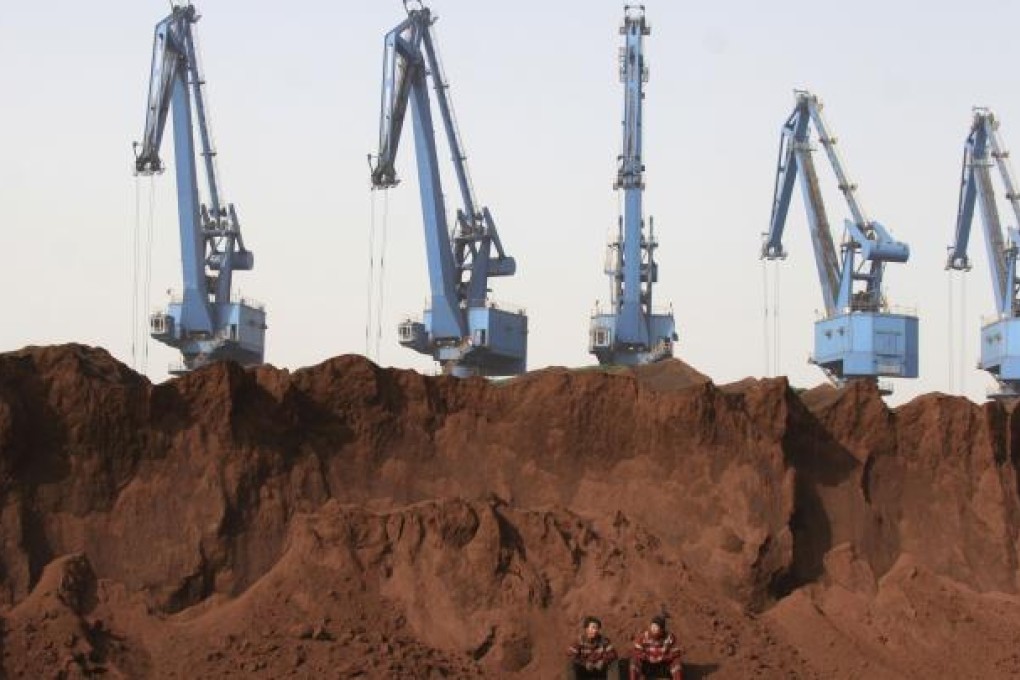 Workers rest near a pile of iron ore in Tianjin Municipality. General Moly and Australia's Sundance Resources have expressed concern about a US$1.4 billion bid from China's Hanlong Group. Photo: Reuters