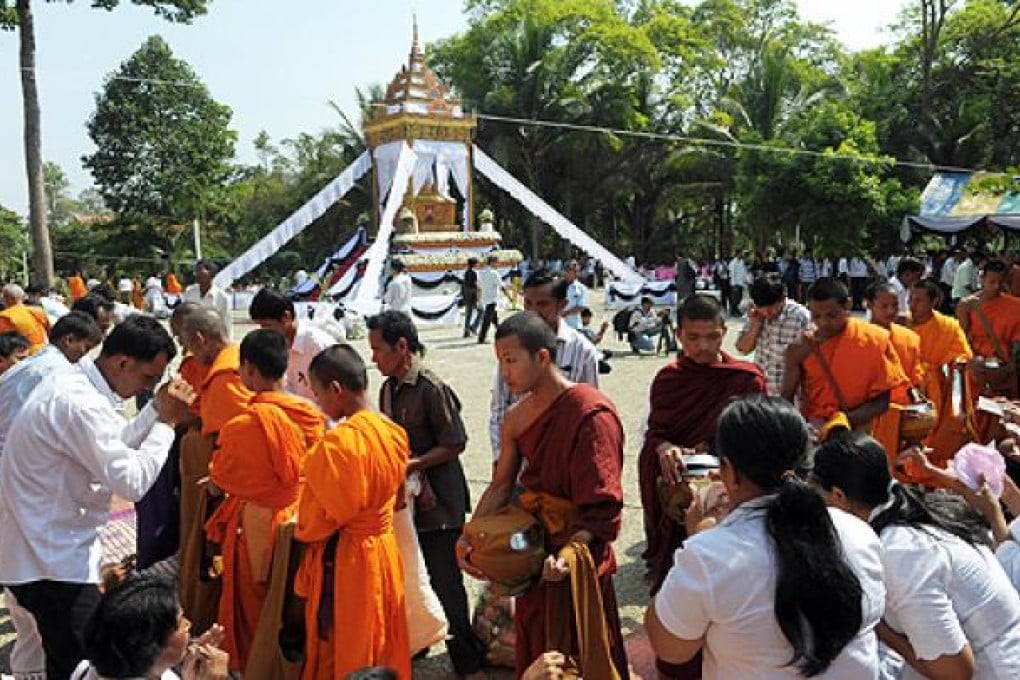 Cambodian people offer alms to Buddhist monks around the cremation site for former Khmer Rouge foreign minister Ieng Sary in Malai on Thursday. Photo: AFP